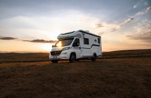 laika camper met laika onderdelen rijdt in natuur met ondergaande zon