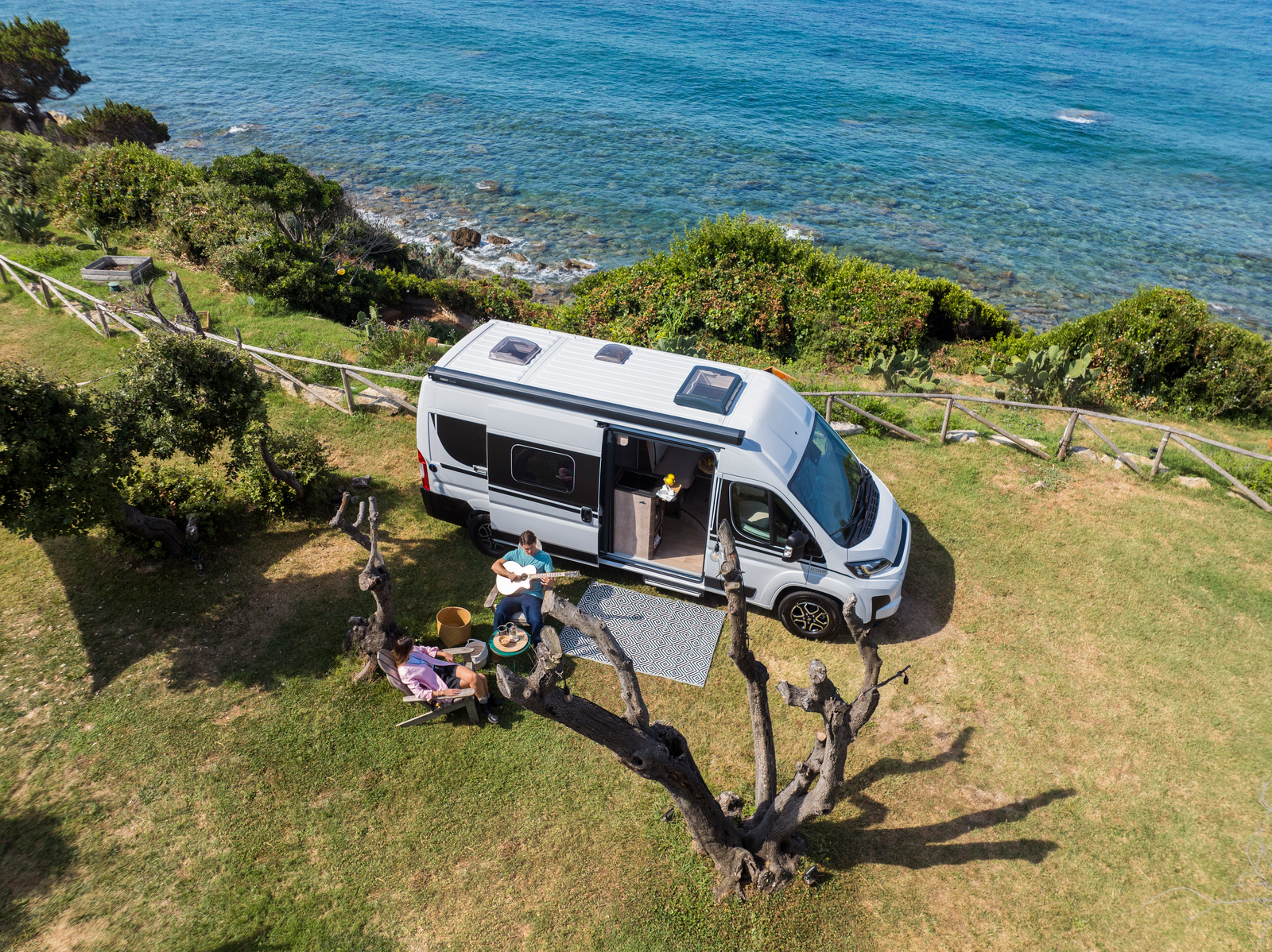 buscamper aan het water met man met gitaar